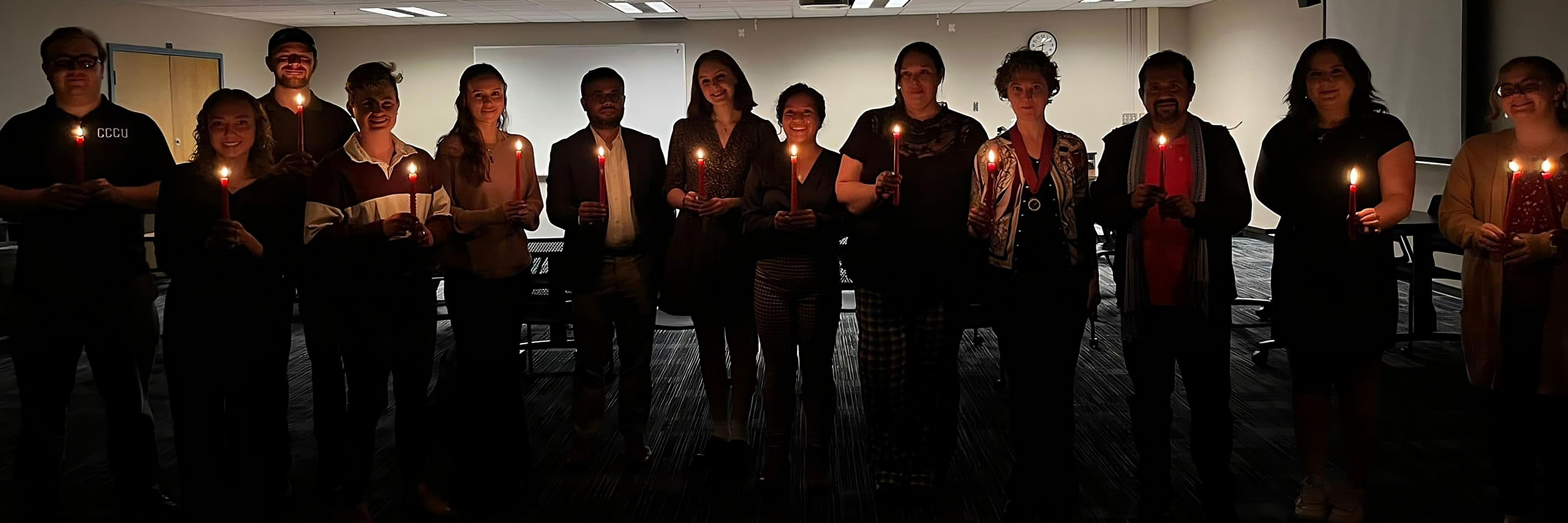 Students holding a lighted candle on a English event
